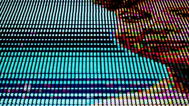 A face rendered in pixels on a large screen