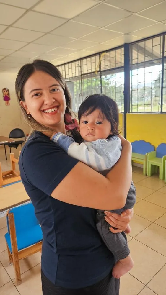 Sharon holding a baby at a children's home in Quito