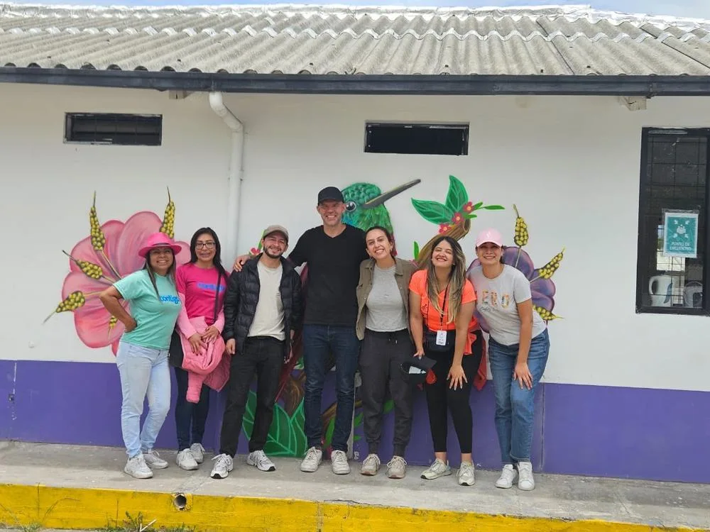 Outreach team in front of a hummingbird mural